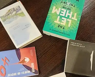 원목 테이블 위에 놓인 여러 권의 책